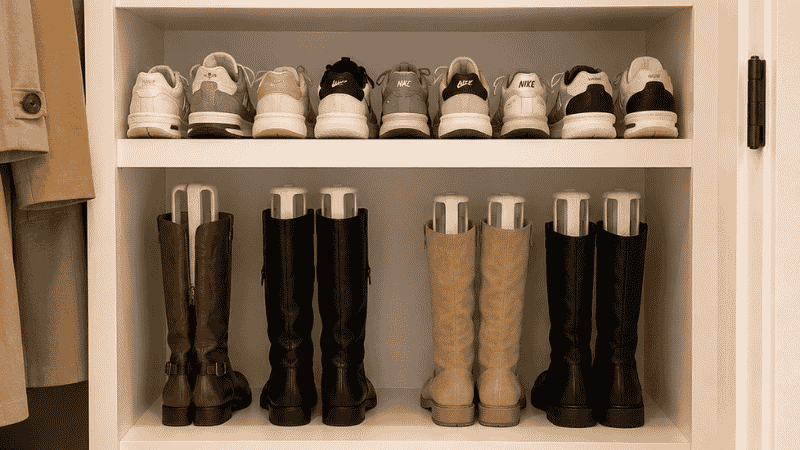 Closet showing four shoe storage methods by type — clear boxes for heels open shelf for sneakers boot shapers for boots floor rack for flats