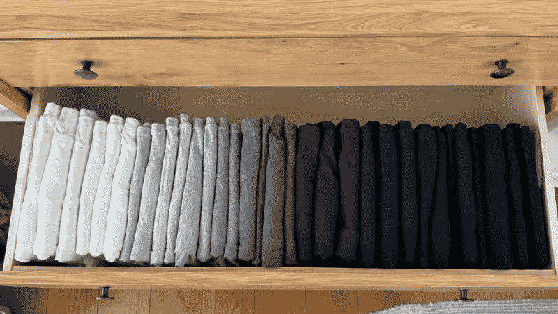 Dresser drawer viewed from above showing vertical file folding method with shirts filed upright in color organized rows
